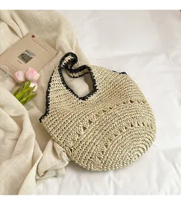 Détail du sac cabas en paille tissé main avec bordure noire et motif ajouré