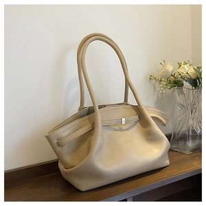 Close-up of beige tote bag with silver buckle strap and decorative dried roses