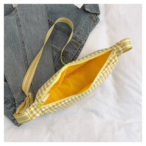 Detailed view of yellow plaid crossbody bag showing yellow lining and inner pocket