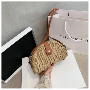 Detailed macro view of woven straw texture and premium brown leather flap with metal clasp
