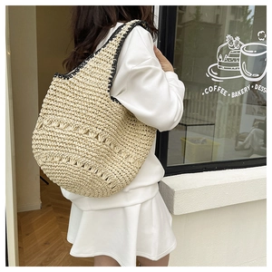 Détail du sac cabas en paille fait main avec bordure contrastée noire et ajouré