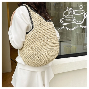 Détail du sac bandoulière en paille avec bordure noire et motifs tissés ajourés pour l'été