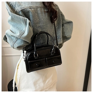 Glossy black leather bowling bag with front pockets styled with a denim jacket