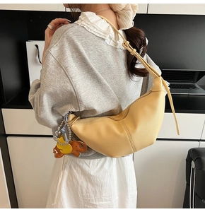 Detail of yellow pebbled leather hobo bag featuring cute elephant and duck charms