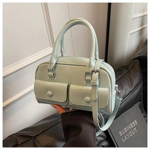 Close-up of mint green Boston bag featuring double front flap pockets and PU leather texture