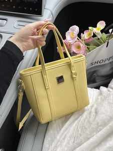 Minimalist bright yellow bucket bag in pebble leather with stylish gold hardware