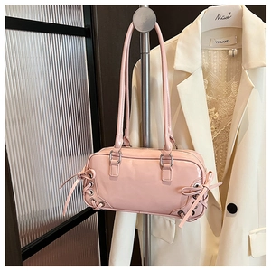 Dettaglio borsa in vernice rosa con fiocchi e occhielli argentati sul lato