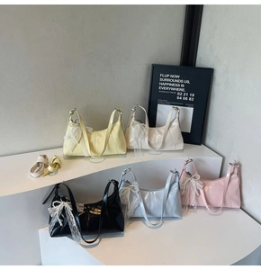 Macro shot of glossy faux leather hobo bags in five colors with lace pearl charms