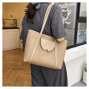 Brown lychee leather tote bag with front wave pocket shown on model in a cafe setting