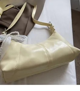 Detail of cream PU leather hobo bag with lace and pearl pendant accessory
