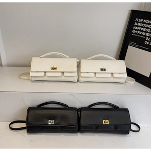 Detail view of stylish baguette bags with metal twist locks in black and white colors