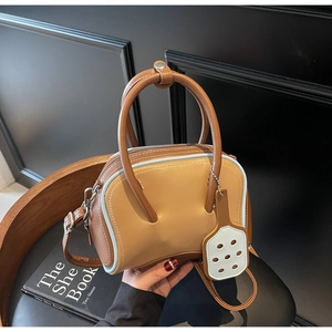 Detail of two-tone Boston bag with light blue piping and thick rounded handles