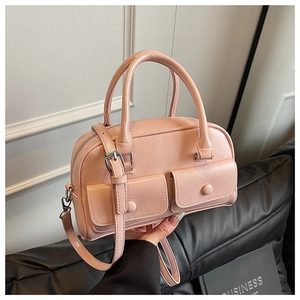Detail of pink leather handbag with double front flap pockets and adjustable shoulder strap