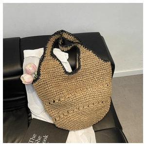 Vue de dessus d'un sac cabas en paille tressée avec bord noir et motifs ondulés