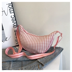 Close-up of pink and white checkered half-moon crossbody bag with striped wide strap