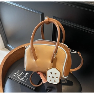 Close-up of a multi-color mini pillow bag with dual handles and stylish leather pendant