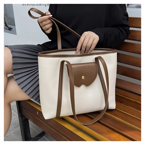 Close-up of contrast color tote bag with beige pebble grain leather and brown flap pocket