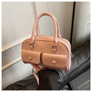 Detail shot of a pink leather pillow bag with double front pockets and refined grain texture