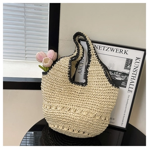Détail du sac cabas en paille fait main avec bordure noire et poignée en U élégante