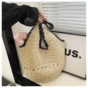 Détail du sac cabas en paille fait main avec coutures noires et motif tissé ajouré