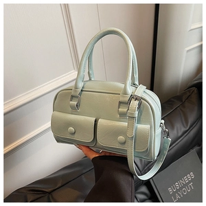 Detail of mint green pillow bag featuring dual front pockets and silver hardware finish