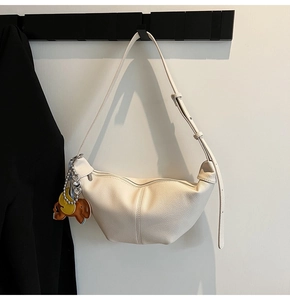 Detail of ivory hobo bag featuring lychee texture leather and cute elephant charm