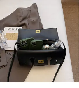 Top view of a black matte baguette bag showing a large interior for phones and cosmetics