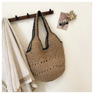 Détail du sac cabas en paille fait main avec bordure noire et bandoulière large