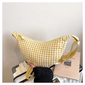 Close-up of yellow plaid crossbody moon bag with textured fabric and striped strap detail