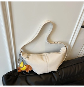 Detail view of cream dumpling bag with lychee grain leather and elephant charm