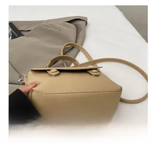 Detail view of the durable bottom base on this beige pebble leather crossbody bag