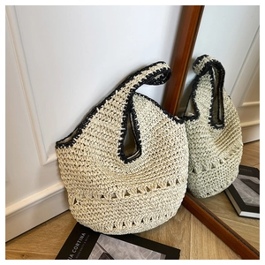 Détail d'un sac à bandoulière en paille fait main avec bordure noire et ajourage