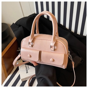 Detailed macro view of light pink leather bag featuring vintage textured grain and snap pockets