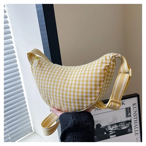 Close-up of yellow and white checkered crescent crossbody bag with adjustable strap
