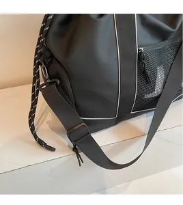 Detailansicht von verstellbarem Nylonschultergurt und Netztasche an der Reisetasche