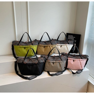 Close-up of durable nylon travel bags in multiple colors featuring orange drawstring detail