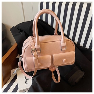 Detail of pink gloss leather Boston bag featuring dual front pockets and silver hardware