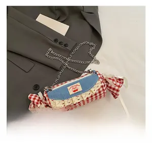 Detail of candy-shaped plaid crossbody bag featuring lace trim and cherry embroidery