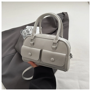 Close-up of light grey Boston bag with front pockets and adjustable shoulder strap