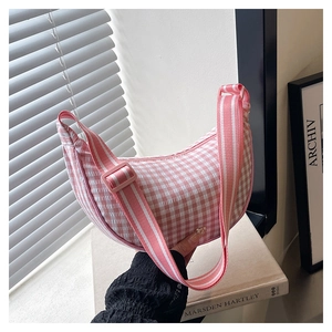 Close-up of pink checkered crescent crossbody bag with adjustable wide fabric strap