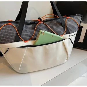 Detail view of large tote bag interior showing a tablet stored in the front zipper pocket