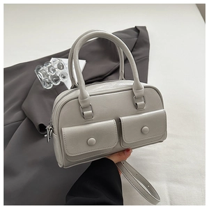 Detail of light grey leather Boston bag with two front pockets and adjustable shoulder strap