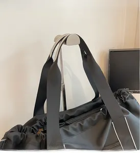 Detail der strapazierfähigen Doppelgriffe und verstärkten Nähte dieser schwarzen Nylontasche