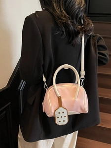 Pink Boston handbag with white contrast handles and tennis racket charm accessory