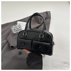 Detail view of a black glossy bowling bag with two front pockets and silver hardware