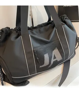 Makroaufnahme der schwarzen Sporttasche mit seitlicher Netztasche und weißem JA-Schriftzug