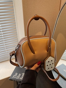 Two-tone leather handbag in brown and tan with light blue piping and round handle