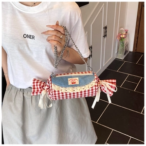 Detail of candy-shaped plaid crossbody bag with denim flap, lace trim, and cherry patch