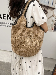 Sac cabas en paille fait main avec bordure noire et motif floral ajouré élégant