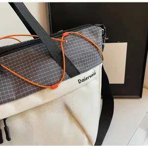 Detail of canvas gym bag showing grid fabric contrast and orange bungee cord